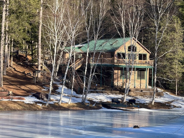 view of outbuilding featuring a water view, a view of trees, and stairs