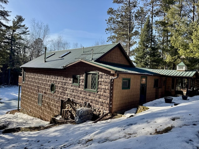 snow covered property featuring metal roof