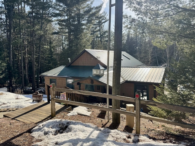 view of home's exterior with metal roof and a view of trees