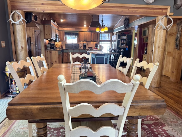 dining room featuring an inviting chandelier, wooden ceiling, and light wood finished floors