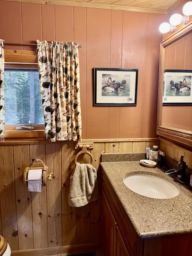 bathroom featuring vanity and a decorative wall