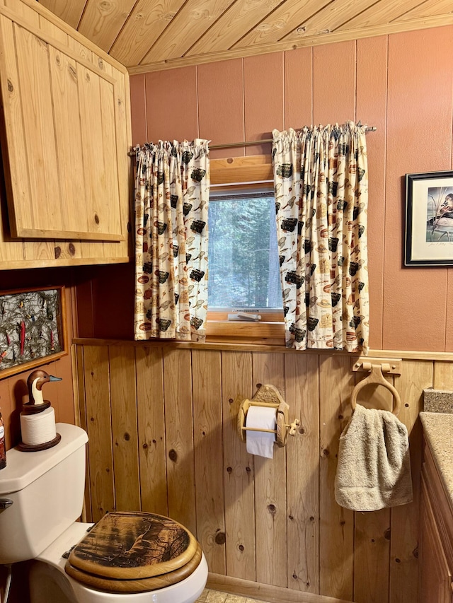 half bath featuring wooden walls, wooden ceiling, and toilet