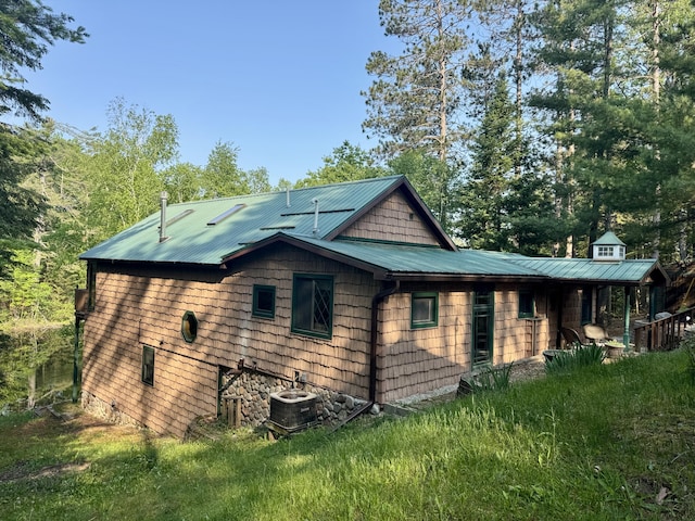 2305 Kirk Rd, Fairview, MI 48621 - view of home's exterior featuring metal roof and central air condition unit