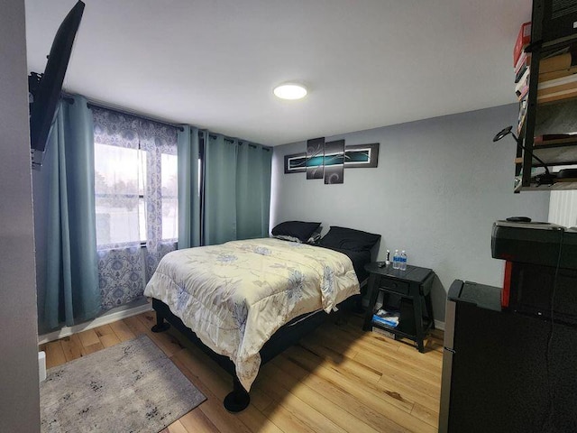 bedroom with baseboards and light wood-style floors