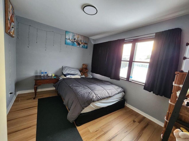 bedroom with wood finished floors and baseboards