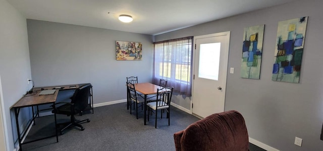 dining room featuring baseboards and dark carpet