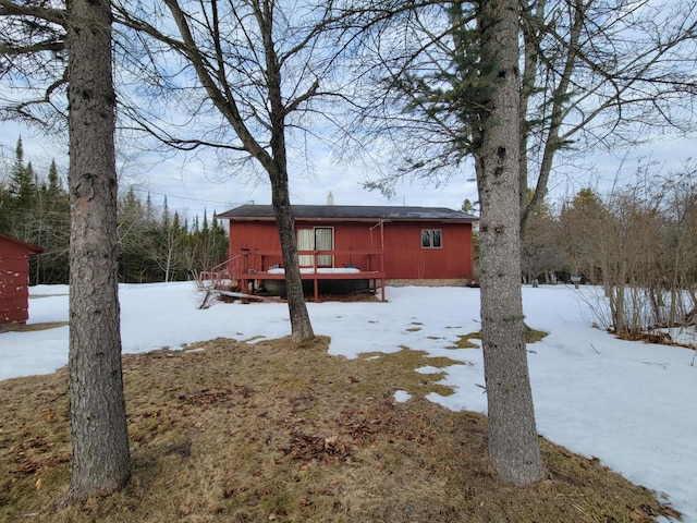 snow covered rear of property featuring a wooden deck