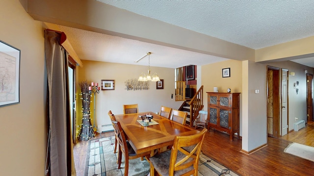 dining area with baseboards, light wood-style flooring, an inviting chandelier, a textured ceiling, and a baseboard radiator