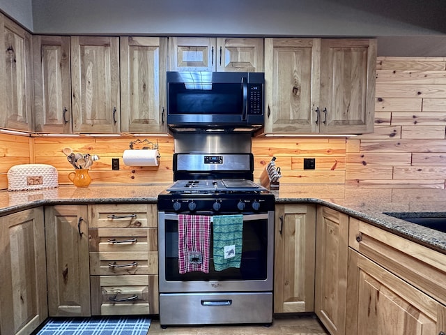 kitchen with backsplash, stainless steel appliances, and light stone countertops