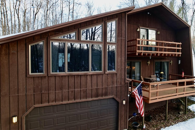 view of property exterior featuring a deck, a balcony, and an attached garage