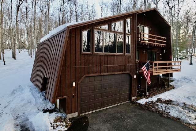 exterior space with a balcony, a gambrel roof, and driveway