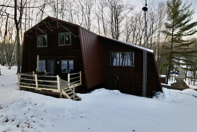 view of front facade featuring a wooden deck and a gambrel roof