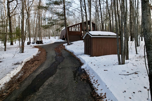 snowy yard with an outbuilding, a shed, and a garage