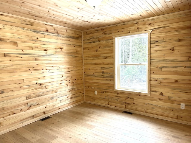 unfurnished room with wooden ceiling, wooden walls, light wood-type flooring, and a sauna