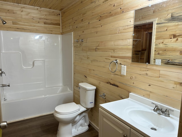 full bath with toilet, wood walls, and vanity
