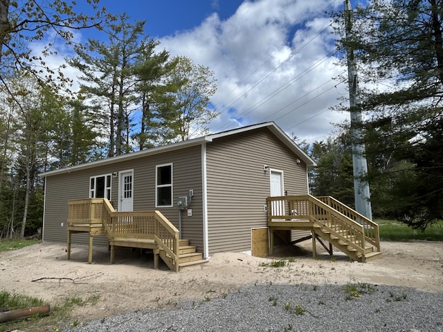 105 Sitting Bull Rd, Alpena, MI 49707 - rear view of house featuring a wooden deck and stairway