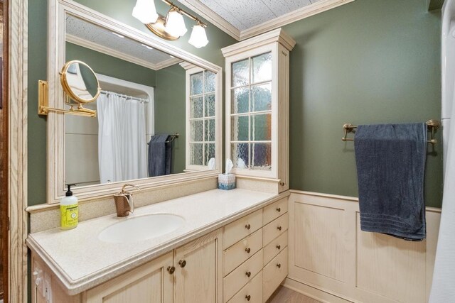 full bath with wainscoting, vanity, and ornamental molding