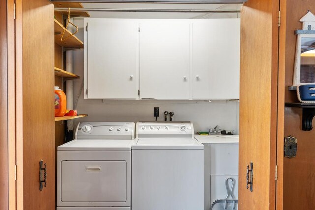 clothes washing area featuring cabinet space and washing machine and dryer