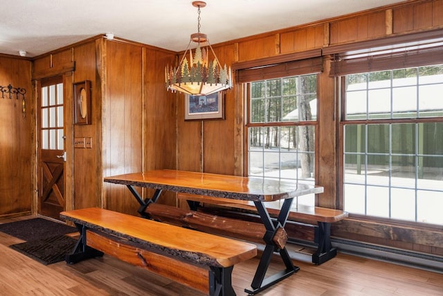 dining room featuring wood finished floors, wood walls, and breakfast area