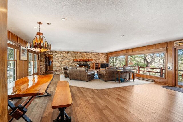 living room featuring a wealth of natural light, a fireplace, a textured ceiling, and wood finished floors