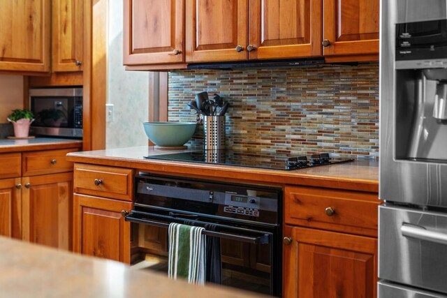 kitchen featuring light countertops, tasteful backsplash, and stainless steel appliances