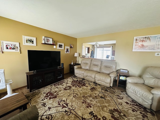 living area with a ceiling fan and wood finished floors