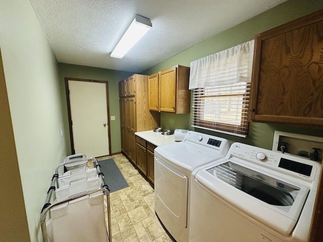 washroom with cabinet space, a textured ceiling, and independent washer and dryer