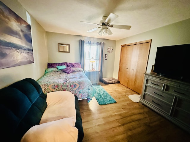 bedroom featuring a closet, wood finished floors, and a ceiling fan