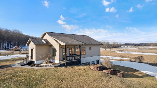 view of front of home featuring roof with shingles and a front yard