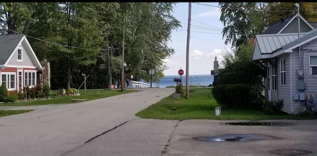 view of road featuring traffic signs and a water view