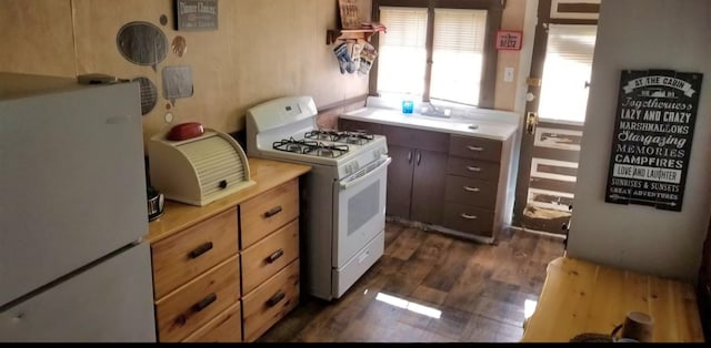 kitchen featuring white appliances, light countertops, and dark wood-style flooring