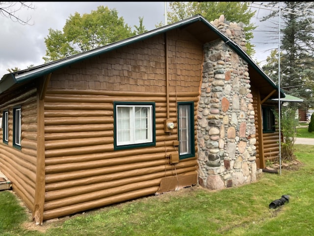 view of home's exterior featuring entry steps and a lawn