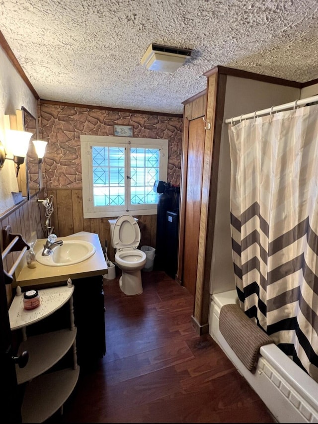 full bath with crown molding, toilet, wood finished floors, a textured ceiling, and vanity