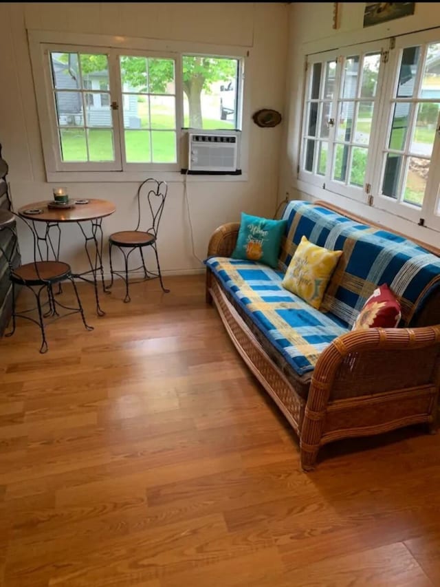 living area with cooling unit and light wood-type flooring