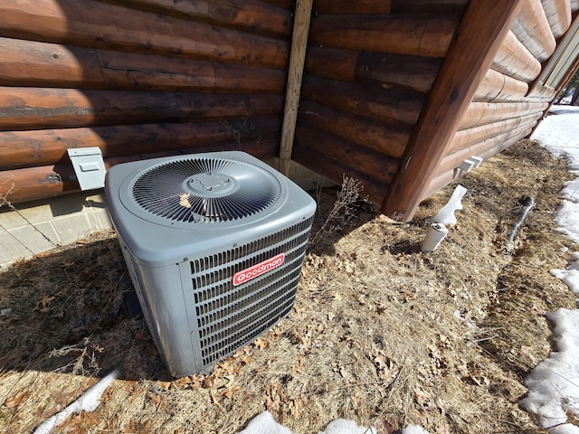 exterior details featuring log veneer siding and central air condition unit