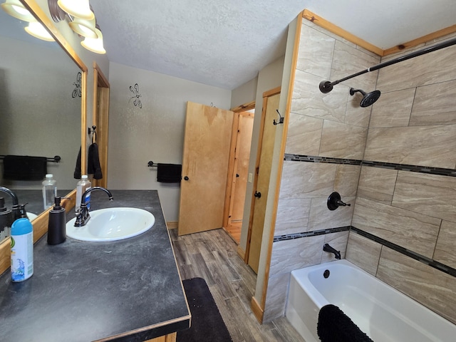 bathroom featuring a textured ceiling, shower / tub combination, vanity, and wood tiled floor