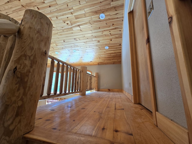 interior space with vaulted ceiling, wooden ceiling, baseboards, and hardwood / wood-style flooring