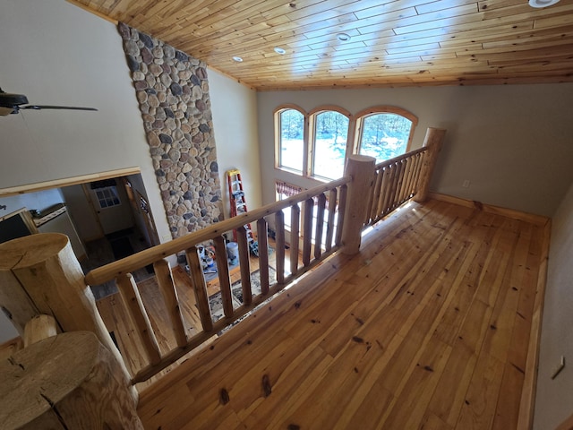 stairway featuring vaulted ceiling, wood ceiling, baseboards, and hardwood / wood-style floors