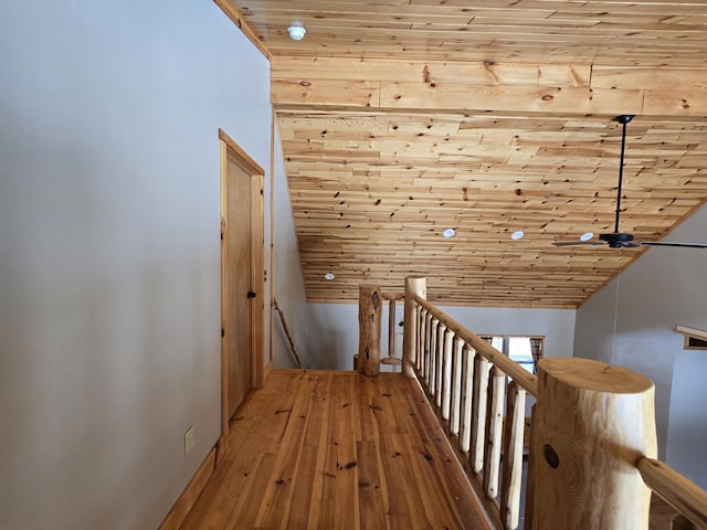 hallway with an upstairs landing, wood ceiling, and hardwood / wood-style flooring