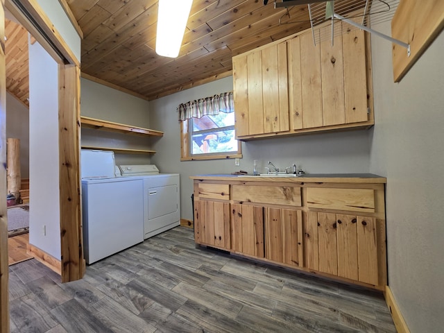 laundry area with washer and clothes dryer, cabinet space, dark wood-type flooring, and a sink