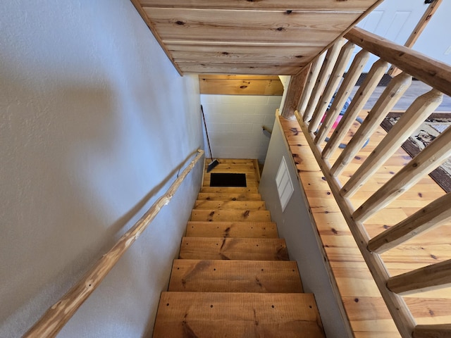 staircase featuring concrete block wall