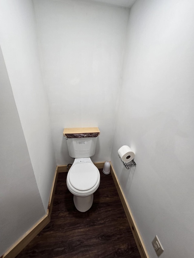 bathroom featuring toilet, wood finished floors, and baseboards