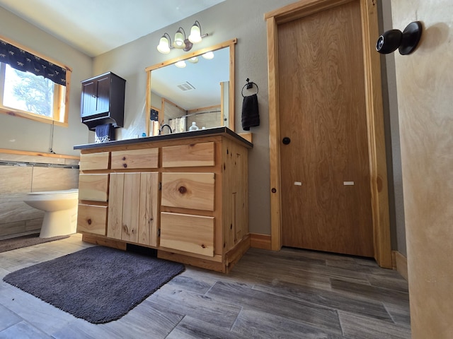 bathroom featuring visible vents, wood finished floors, and vanity