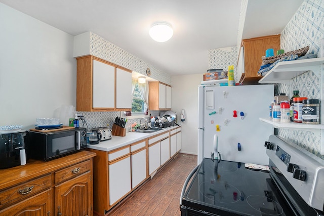 1114 Brooktrout Ln, Gaylord, MI 49735 - kitchen with freestanding refrigerator, stainless steel range with electric cooktop, black microwave, light countertops, and wood finished floors