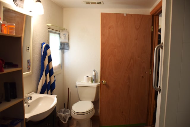 1467 N Black River Rd, Cheboygan, MI 49721 - bathroom with vanity, toilet, and a textured wall