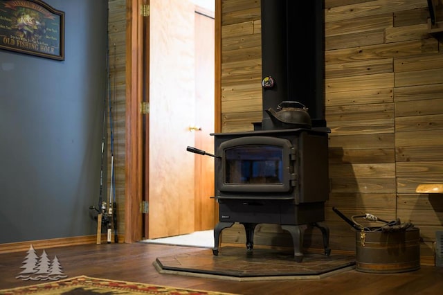 6122 Beach Rd, Johannesburg, MI 49751 - details featuring wood finished floors, wooden walls, and a wood stove