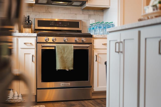 3211 Jenson St, Lewiston, MI 49756 - kitchen with light countertops, gas stove, decorative backsplash, dark wood-type flooring, and extractor fan
