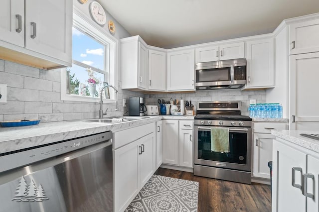 3211 Jenson St, Lewiston, MI 49756 - kitchen featuring dark wood-type flooring, white cabinetry, a sink, and appliances with stainless steel finishes