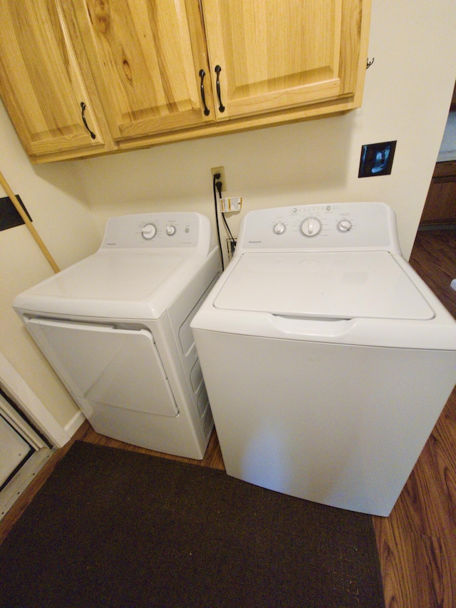 638 Old Trail Dr, Houghton Lake, MI 48629 - laundry room with washing machine and dryer, wood finished floors, and cabinet space
