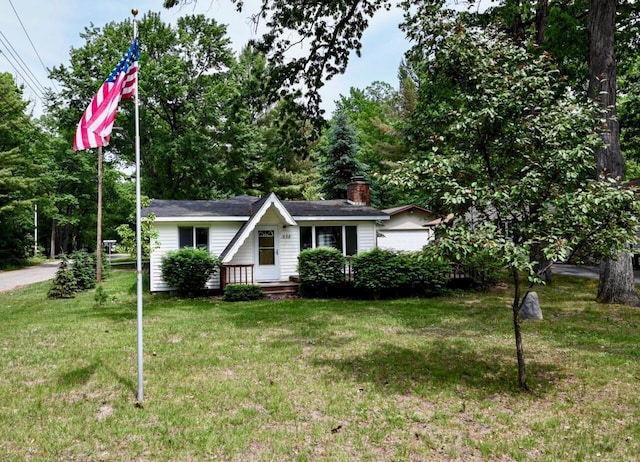 638 Old Trail Dr, Houghton Lake, MI 48629 - view of front facade featuring a front yard and a chimney